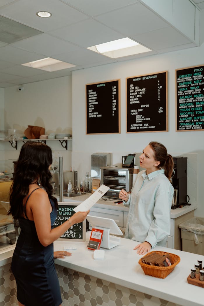 our-story A barista assists a customer at the counter in a modern, well-lit coffee shop.