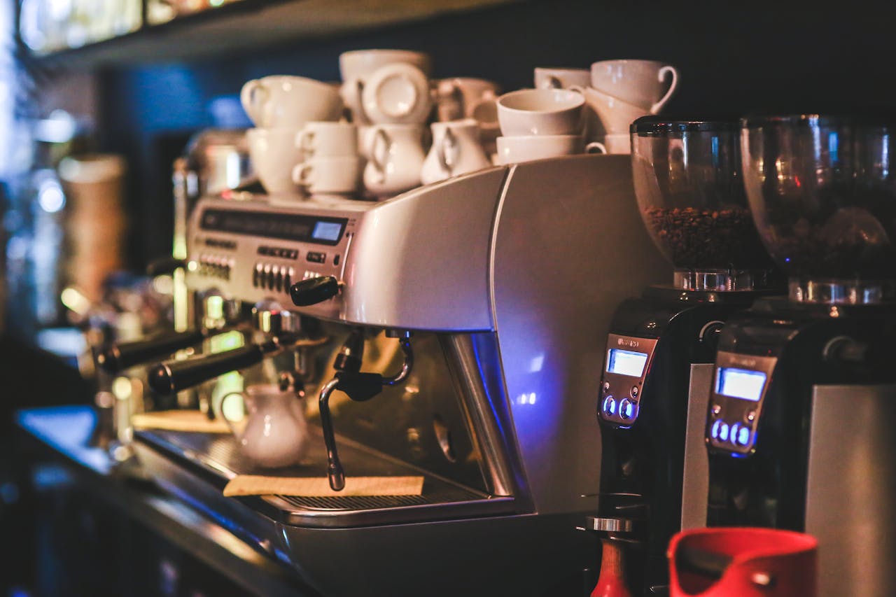 home-hero Espresso machine with cups in a dimly lit café offering a cozy ambiance.